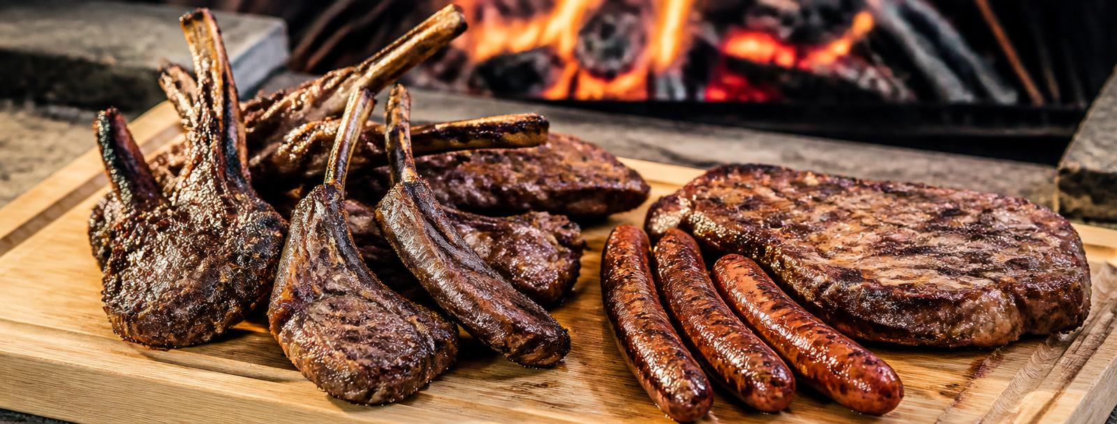 Fleisch über offener Holzkohle, eine Hand wendet es mit der Zange